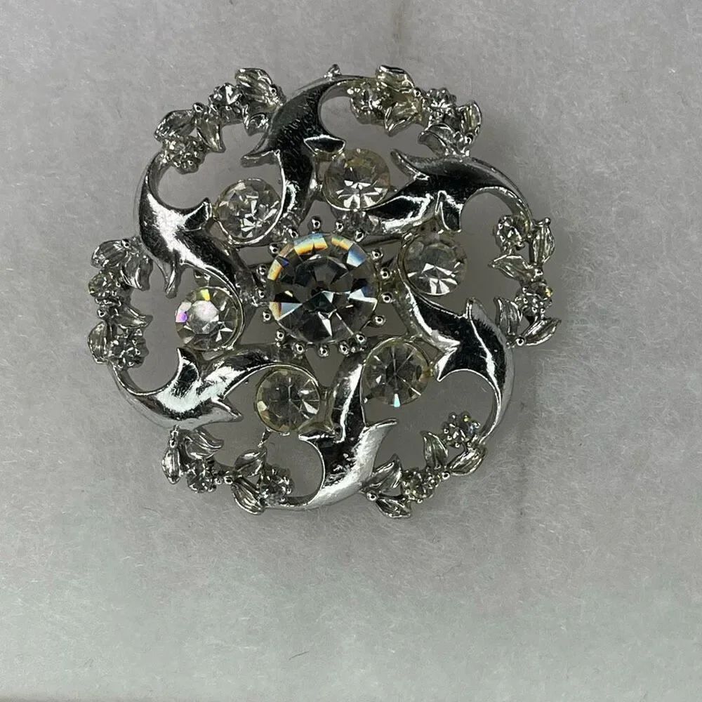 Vintage rhinestone swirl starbust open cut atomic area brooch.